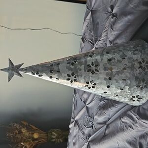 Galvanized Christmas tree with cut-out snowflakes.